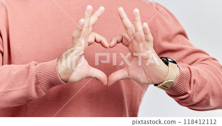 Hands, heart and man with love in studio to show support, thank you or charity sign language. Male model person with hand icon for kindness, care and hope review, motivation or emoji opinion feedback 118412112