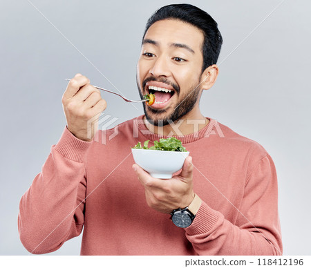 Man, salad and eating healthy food in studio for health or wellness motivation for vegetables. Asian male vegetable bowl for nutrition, diet and benefits for digestion or lose weight white background Man, salad and eating healthy food in studio for health or wellness motivation for vegetables. Asian male vegetable bowl for nutrition, diet and benefits for digestion or lose weight white background 118412196