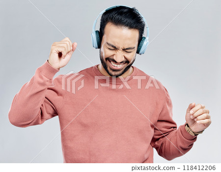 Fun, dance and Asian man with headphones, streaming music and happiness against a grey studio background. Japan, male and guy with headset, listening radio and sounds with movement, silly and smile 118412206