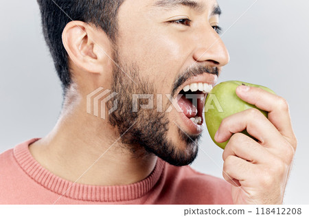 Man is eating apple, health and nutrition with fruit, diet with healthy food and wellness on studio background. Closeup, vegan male and detox with weight loss, healthcare and organic fruits 118412208