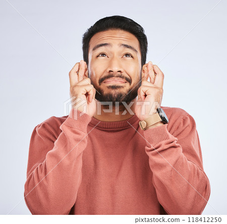 Fingers crossed, hope and man with hands for good luck, anxiety or trust for bonus on white background in studio. Nervous asian male person wish for belief, emoji and prayer for winning lottery prize 118412250