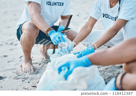 Volunteer, hands of people cleaning beach for world earth day with nature care and kindness for natural environment. Help, recycling and ngo team picking up plastic waste and pollution on ocean sand. 118412387