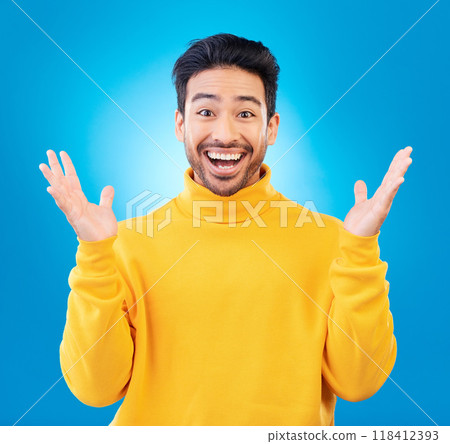 Wow, excited man and surprise portrait in studio with Asian model with teeth and joy. Blue background, male person and casual fashion with handsome and friendly guy with modern style and happy 118412393