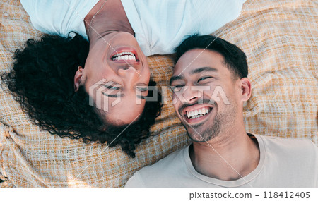 Face, picnic and smile with a couple laughing on a blanket from above, lying on the ground while on a date. Love, happy or funny with a man and woman bonding together for romance on valentines day 118412405