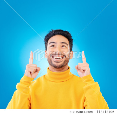 Happy, casual and man pointing up, promotion and winning against a blue studio background. Male person, guy or model with happiness, mockup space and decision with choice, excited and creative design 118412406