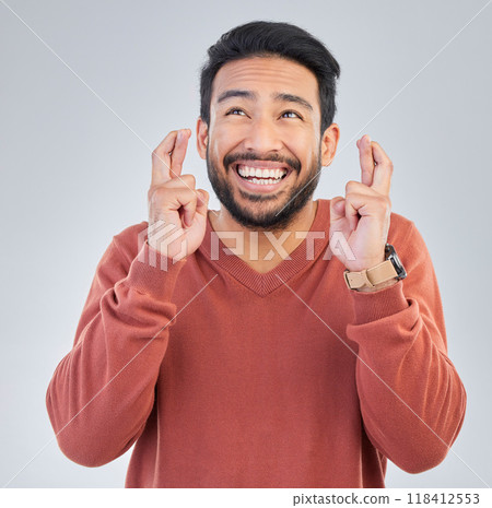 Thinking, luck and hand gesture with a man in studio on a gray background praying in hope of a miracle. Idea, smile and fingers crossed with a happy or handsome young male wishing for good fortune Thinking, luck and hand gesture with a man in studio on a gray background praying in hope of a miracle. Idea, smile and fingers crossed with a happy or handsome young male wishing for good fortune 118412553