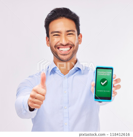 Asian man, portrait and phone with thumbs up for transaction approval against a white studio background. Happy male smile showing thumb emoji, yes sign or like for electronic purchase on smartphone Asian man, portrait and phone with thumbs up for transaction approval against a white studio background. Happy male smile showing thumb emoji, yes sign or like for electronic purchase on smartphone 118412616
