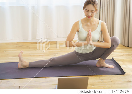A young woman showing poses in an online yoga salon broadcast A young woman showing poses in an online yoga salon broadcast 118412679