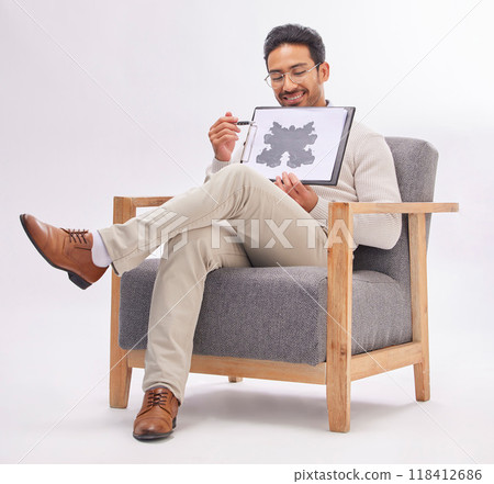 Psychology, psychologist and man with rorschach test diagram on clipboard in studio isolated on a white background. Therapist, consultant or happy male sitting on chair with document for inkblot exam 118412686