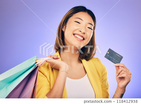 Asian woman, credit card and shopping bag in studio portrait with smile for deal, sale or discount by background. Japanese girl, retail and happy with banking, budget or luxury by purple background Asian woman, credit card and shopping bag in studio portrait with smile for deal, sale or discount by background. Japanese girl, retail and happy with banking, budget or luxury by purple background 118412938