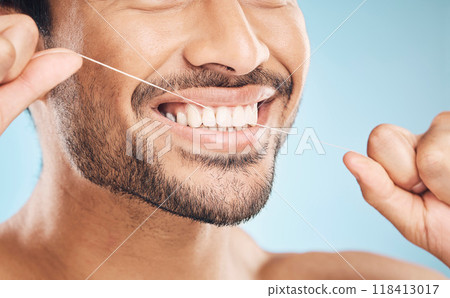Wellness, teeth closeup and flossing of a man with cleaning and dental health in a studio. Face, blue background and healthy male person with dental floss for mouth hygiene and healthcare with smile 118413017