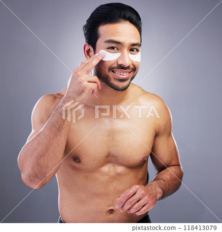 Portrait, beauty or happy man with eye patch for skincare or wellness isolated on studio background. Cosmetics, smile or model with facial collagen pads or dermatology product for anti aging or glow 118413079