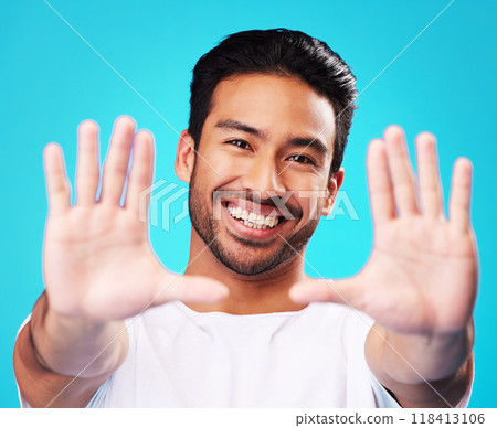 Portrait, hands and man frame face in studio to review profile picture on blue background. Happy young asian model planning perspective of photography, selfie and creative inspiration for border sign 118413106