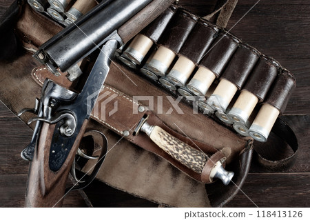 hunting double barreled side shotgun with cartridges in bandolier. 118413126