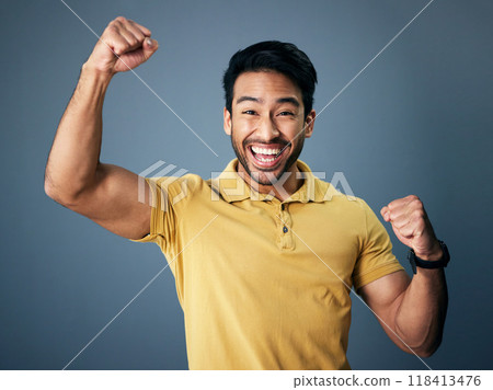 Indian man, celebrate and fist in studio portrait for winning mindset, happiness or achievement by background. Young model, male student or celebration with happy, excited face or winning for success 118413476