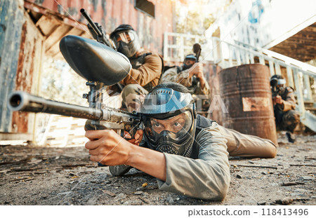 Paintball, team and people in action with gun for tournament, competition and battle in nature. Sports, military and men on ground shooting in outdoor arena for training, adventure games or challenge 118413496