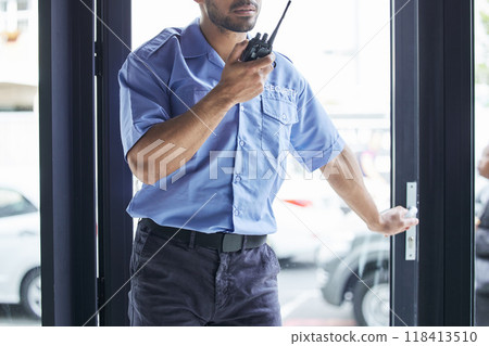 Man, radio and talking at security job in city, communication or contact for backup, support or safety in building. African protection agent, audio tech or report info in metro, cbd or door for crime 118413510