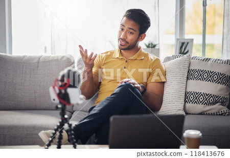 Content creator, laptop and phone, Indian man on sofa recording webinar, broadcast and live streaming in home. Internet, webcam and online influencer talking with equipment for social media channel. Content creator, laptop and phone, Indian man on sofa recording webinar, broadcast and live streaming in home. Internet, webcam and online influencer talking with equipment for social media channel. 118413676