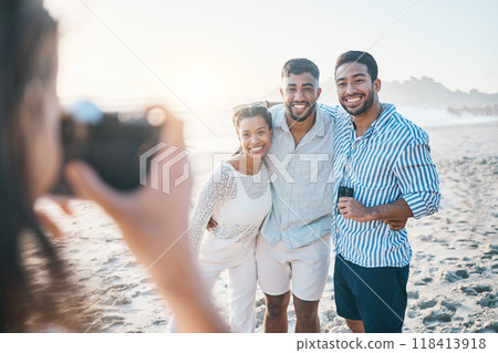 Happy, photo and friends at the beach with a photographer for summer memory, holiday or bonding. Smile, camera and a woman taking a picture of a group of people at the ocean during a vacation Happy, photo and friends at the beach with a photographer for summer memory, holiday or bonding. Smile, camera and a woman taking a picture of a group of people at the ocean during a vacation 118413918