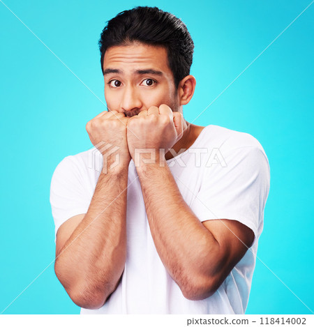 Fear, scared and portrait of man nervous, anxiety or anxious due to crisis or stress isolated in a studio blue background. Worry, suspense and young male person hands in face for mistake reaction Fear, scared and portrait of man nervous, anxiety or anxious due to crisis or stress isolated in a studio blue background. Worry, suspense and young male person hands in face for mistake reaction 118414002