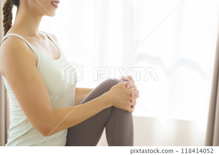 A young woman taking an online yoga class at home 118414052