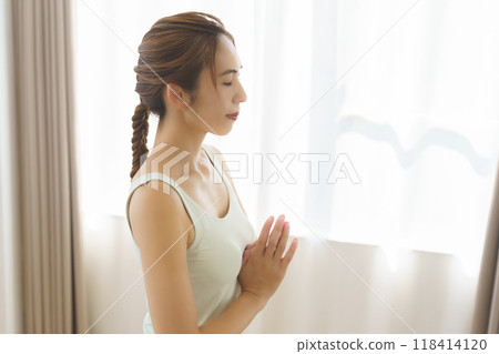 A young woman taking an online yoga class at home A young woman taking an online yoga class at home 118414120