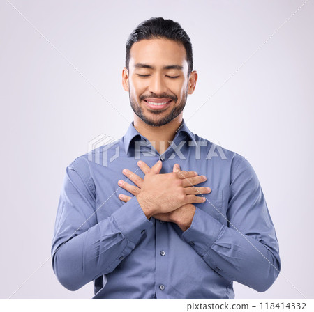 Pray, hands on chest and happy man in studio with self love, hope and love on grey background. Praying, hand and open heart gesture by male show emoji, gratitude and calm zen while standing isolated Pray, hands on chest and happy man in studio with self love, hope and love on grey background. Praying, hand and open heart gesture by male show emoji, gratitude and calm zen while standing isolated 118414332