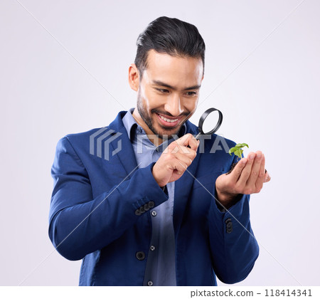 Magnifying glass, plant and growth with man in studio for investment, search and zoom. Knowledge, discover and investigation with employee on gray background for study, analysis and curiosity Magnifying glass, plant and growth with man in studio for investment, search and zoom. Knowledge, discover and investigation with employee on gray background for study, analysis and curiosity 118414341