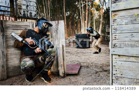 Sports, paintball and man with gun for battle, game or competition outdoors on field. War, military camouflage and male soldier with weapon on shooting range to hide from player in exercise fight. 118414389