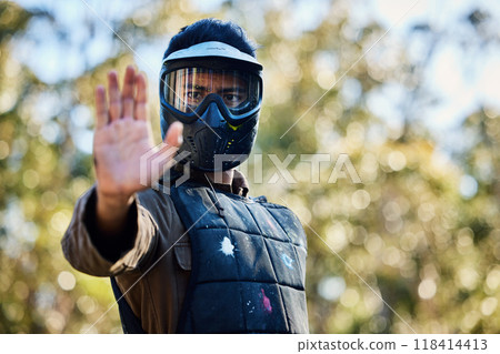 Man, paintball and hands in stop signal for team communication or strategy on the battlefield in nature. Male paintballer or soldier showing hand sign halt or wait in adrenaline sport outdoors Man, paintball and hands in stop signal for team communication or strategy on the battlefield in nature. Male paintballer or soldier showing hand sign halt or wait in adrenaline sport outdoors 118414413