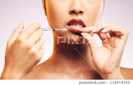 Beauty, lip filler and hands with botox injection, plastic surgery and portrait of cosmetic dermatology in studio background. Lips of woman, syringe and model with aesthetic facial treatment Beauty, lip filler and hands with botox injection, plastic surgery and portrait of cosmetic dermatology in studio background. Lips of woman, syringe and model with aesthetic facial treatment 118414545