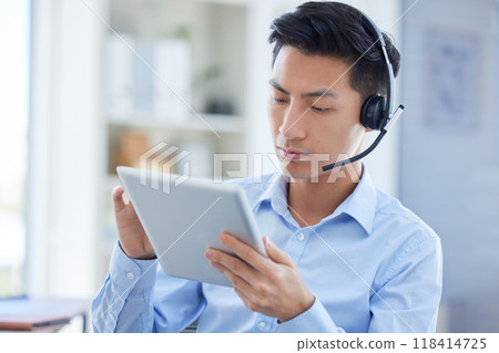 Call center, tablet and focus with asian man in office for consulting, customer service and contact us. Communication, focus and help desk with male employee for technology, digital and networking 118414725