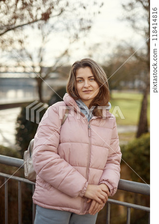 Young beautiful pretty tourist girl in warm hat and coat with backpack walking at cold autumn in Europe city enjoying her travel in Bietigheim-Bissingen, Deutschland. Outdoor portrait of young tourist 118414816