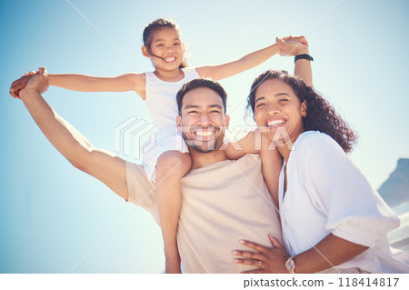 Portrait, beach and happy family smile, piggyback and bond outdoor against blue sky background. Travel, face and girl with parents on an ocean vacation, holiday or trip in Miami, excited and cheerful 118414817