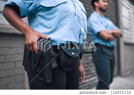 Hand, gun and security with a police officer on duty or patrol in the city for safety and law enforcement. Legal, service and armed response with a guard outdoor in an urban town for crime prevention Hand, gun and security with a police officer on duty or patrol in the city for safety and law enforcement. Legal, service and armed response with a guard outdoor in an urban town for crime prevention 118415110