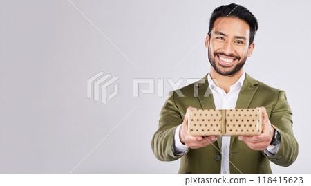 Gift, box and portrait of a man in a studio for a celebration or birthday or event with mockup space. Present, happy and male model from Mexico giving a souvenir with happiness by a gray background. Gift, box and portrait of a man in a studio for a celebration or birthday or event with mockup space. Present, happy and male model from Mexico giving a souvenir with happiness by a gray background. 118415623