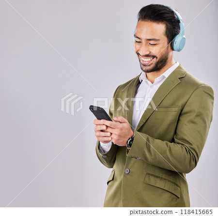 Asian man, phone and smile in social media with headphones for communication against a gray studio background. Happy formal male smiling on smartphone with headset listening to music on mockup Asian man, phone and smile in social media with headphones for communication against a gray studio background. Happy formal male smiling on smartphone with headset listening to music on mockup 118415665