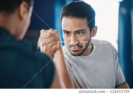 Arm wrestling, men and strength challenge with strong muscle at a gym for battle. Hand wrestle, power and male friends or athletes together for sport, competition or contest with focus and commitment 118415795