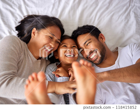 Fun, bed and happy family playing, wake up and happy from above, tickle and laughing in their home. Bedroom, games and girl with parents, smile and laugh, relax and love in their house on the weekend 118415852