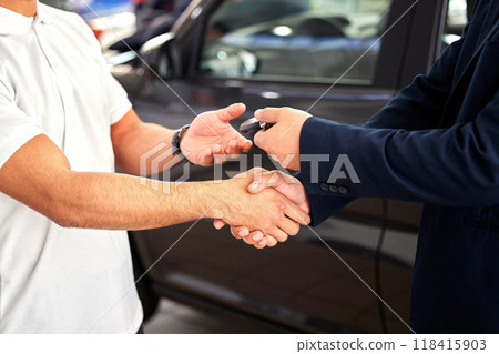 Car dealership, man hands and handshake from purchase and loan deal at motor showroom with salesman. Male person with shaking hands from agreement, payment success and contract with a transport sale 118415903