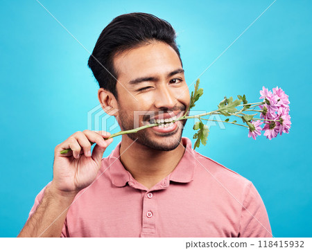 Teeth, flower and wink with portrait of man in studio for celebration, gift and romance. Funny, goofy and present with male isolated on blue background for flirting, smile and valentines day mockup 118415932