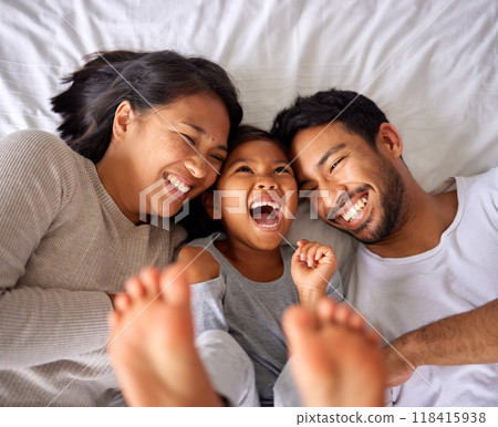 Bed, fun and happy family playing, wake up and happy from above, tickle and laughing in their home. Bedroom, games and girl with parents, smile and laugh, relax and love in their house on the weekend 118415938