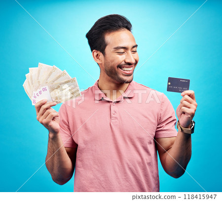 Smile, money and credit card by happy man in studio with savings, finance or investment growth on blue background. Cash, joy and asian guy excited for banking, success or financial freedom isolated 118415947
