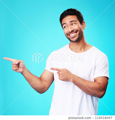 Mockup, pointing and man with a smile, thinking and choice against a blue studio background. Male person, decision or model with product placement, hand gesture and presentation with sign and showing 118416047