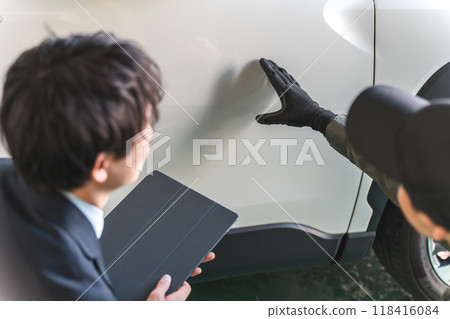 一名男性機械師和穿著西裝的推銷員檢查汽車是否有刮痕和凹痕。 一名男性機械師和穿著西裝的推銷員檢查汽車是否有刮痕和凹痕。 118416084