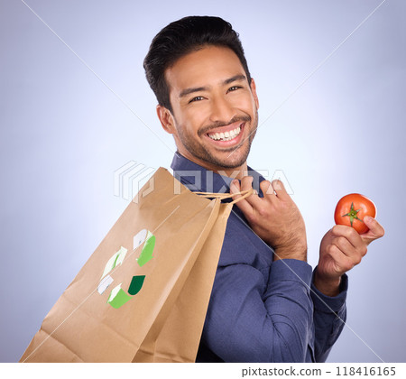 Man in portrait, happy and recycling paper bag with tomato and sustainable shopping on studio background. Eco friendly, vegetable and climate change awareness in retail, sustainability and health Man in portrait, happy and recycling paper bag with tomato and sustainable shopping on studio background. Eco friendly, vegetable and climate change awareness in retail, sustainability and health 118416165