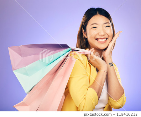 Happy, portrait and woman with shopping bag, retail and commerce with fashion sale on purple background. Discount at boutique shop, Asian female customer and market with store promotion in studio 118416212