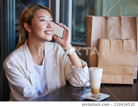 Phone call, shopping mall and Asian woman in cafe with coffee talking, chatting and in conversation. Communication, fashion and happy girl on mockup smartphone for discount news, retail deal and sale Phone call, shopping mall and Asian woman in cafe with coffee talking, chatting and in conversation. Communication, fashion and happy girl on mockup smartphone for discount news, retail deal and sale 118416510