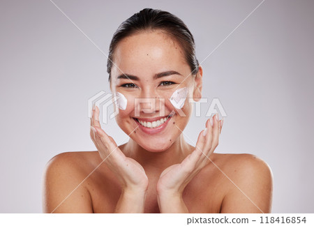 Skincare, portrait and face cream for woman in studio for wellness, grooming and cosmetics on grey background. Facial model and asian girl relax with luxury beauty, skin and treatment with product 118416854