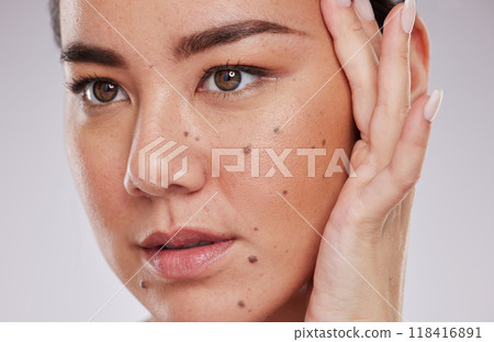 Beauty, face and skincare of a woman in studio for makeup, dermatology and cosmetics for skin glow. Aesthetic asian model person with hand to show mole and facial self care for health and wellness 118416891